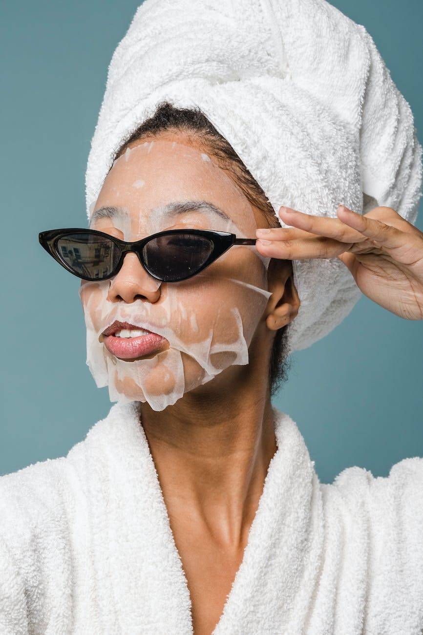 content young black woman wearing sunglasses during skin care treatment after bath